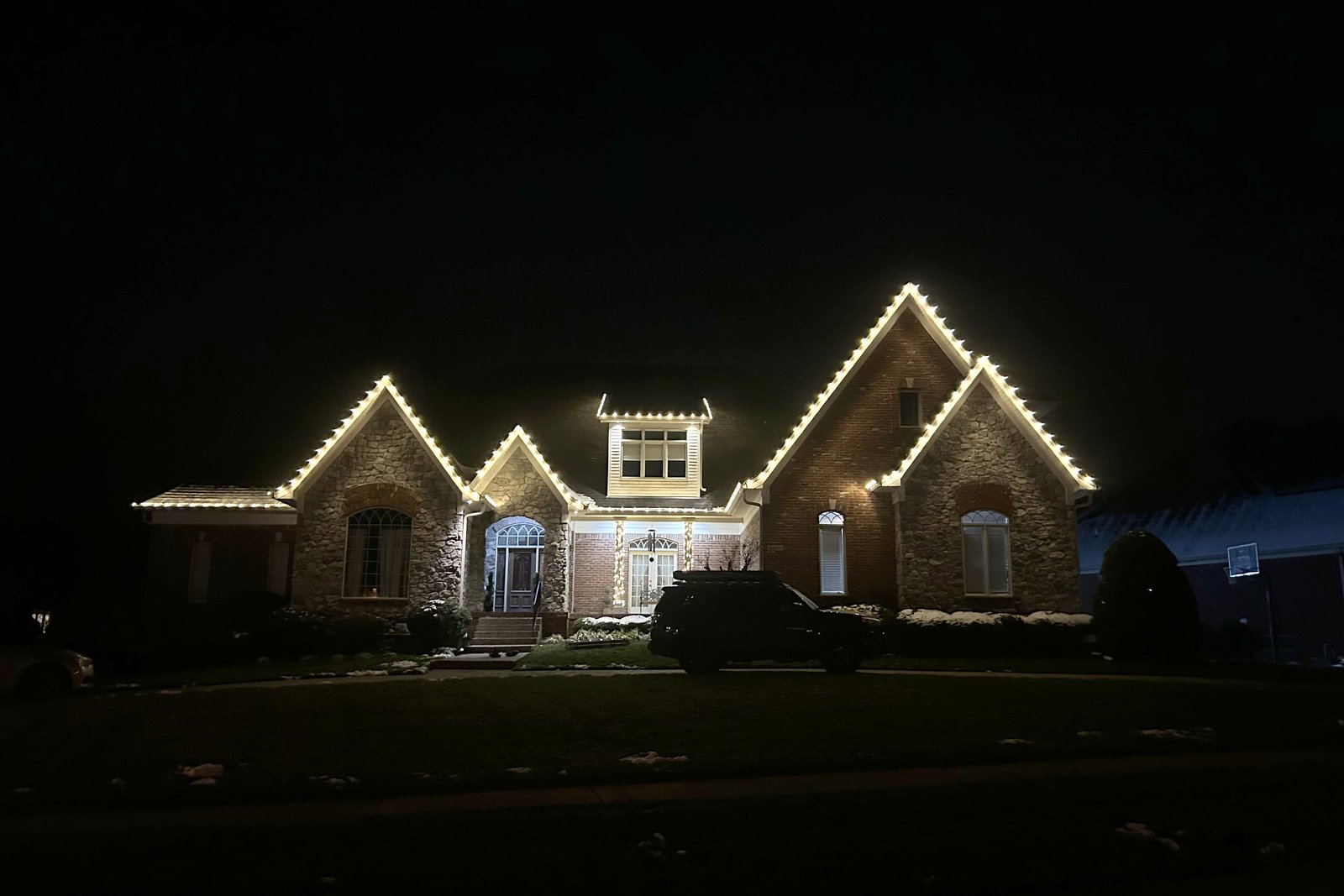 Warm white Christmas lights along a three-gable roofline in Middletown, Kentucky